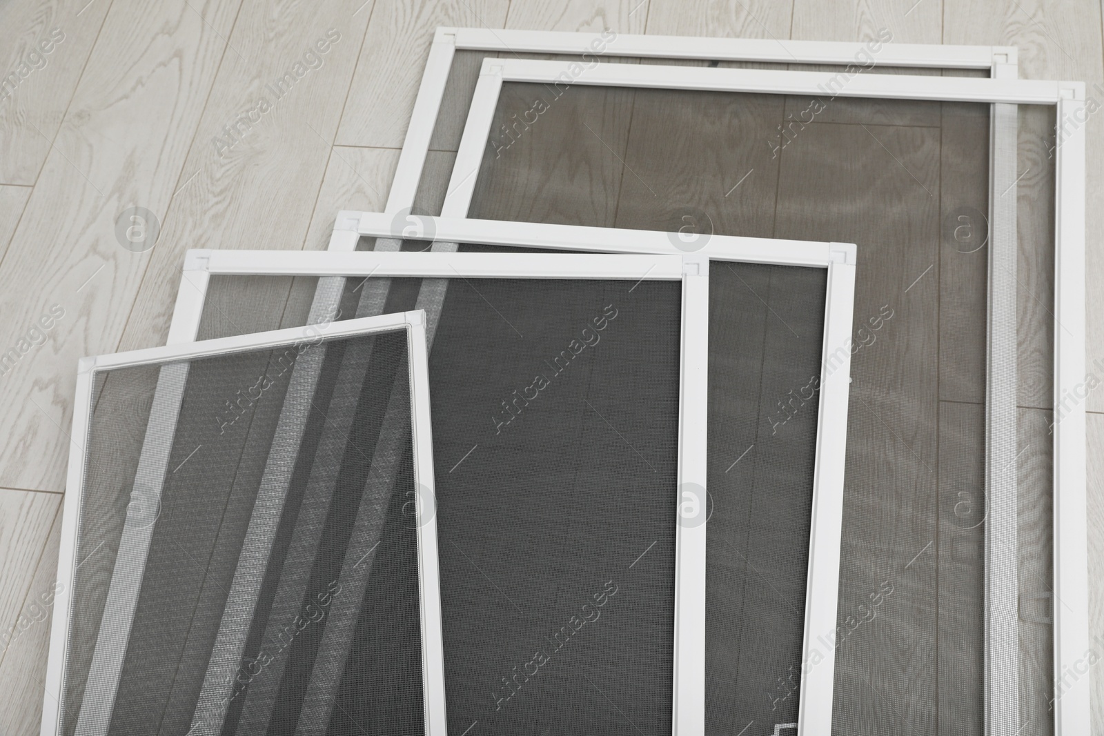 Photo of Set of window screens on wooden floor