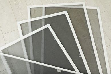 Photo of Set of window screens on wooden floor, flat lay