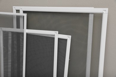 Photo of Set of window screens near beige wall, closeup