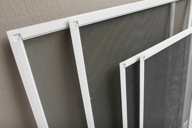 Set of window screens near beige wall, closeup