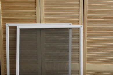 Photo of New window screens near wooden folding screen