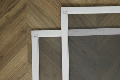 Photo of New window screens on wooden floor, flat lay