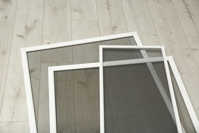 Photo of Set of window screens on wooden floor, above view