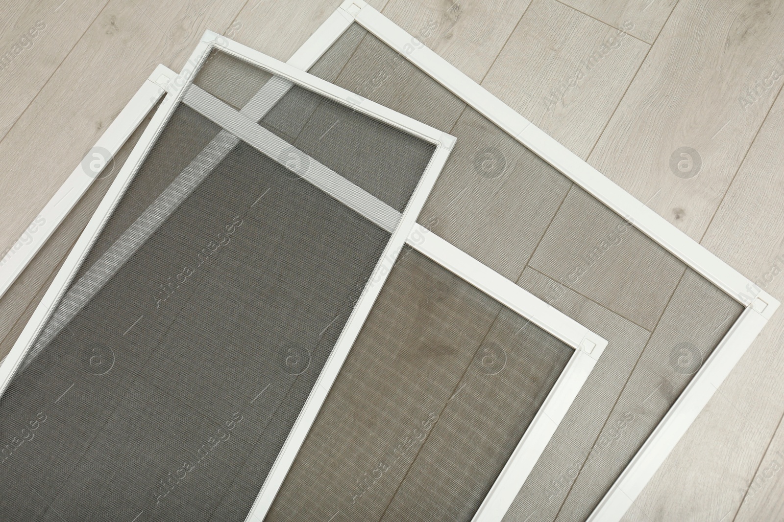 Photo of Set of window screens on wooden floor, flat lay