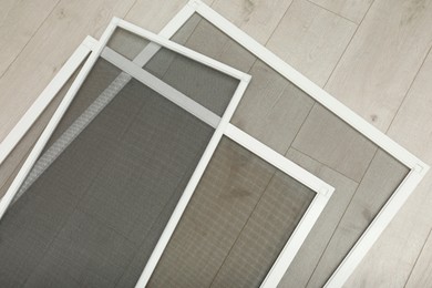 Set of window screens on wooden floor, flat lay