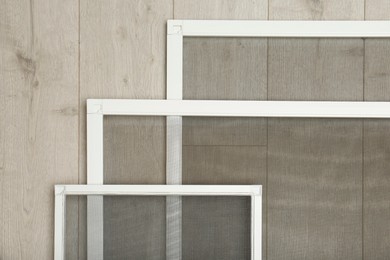 Set of window screens on wooden floor, flat lay