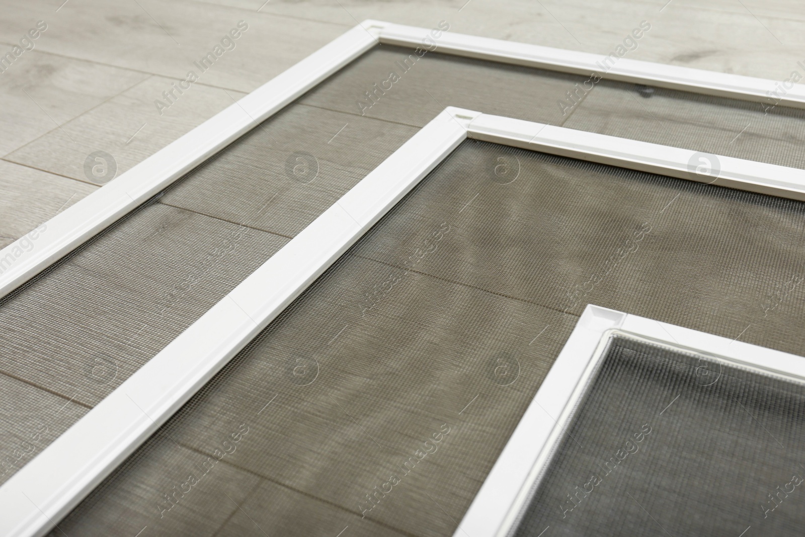 Photo of Set of window screens on wooden floor, closeup