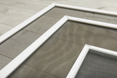 Set of window screens on wooden floor, closeup