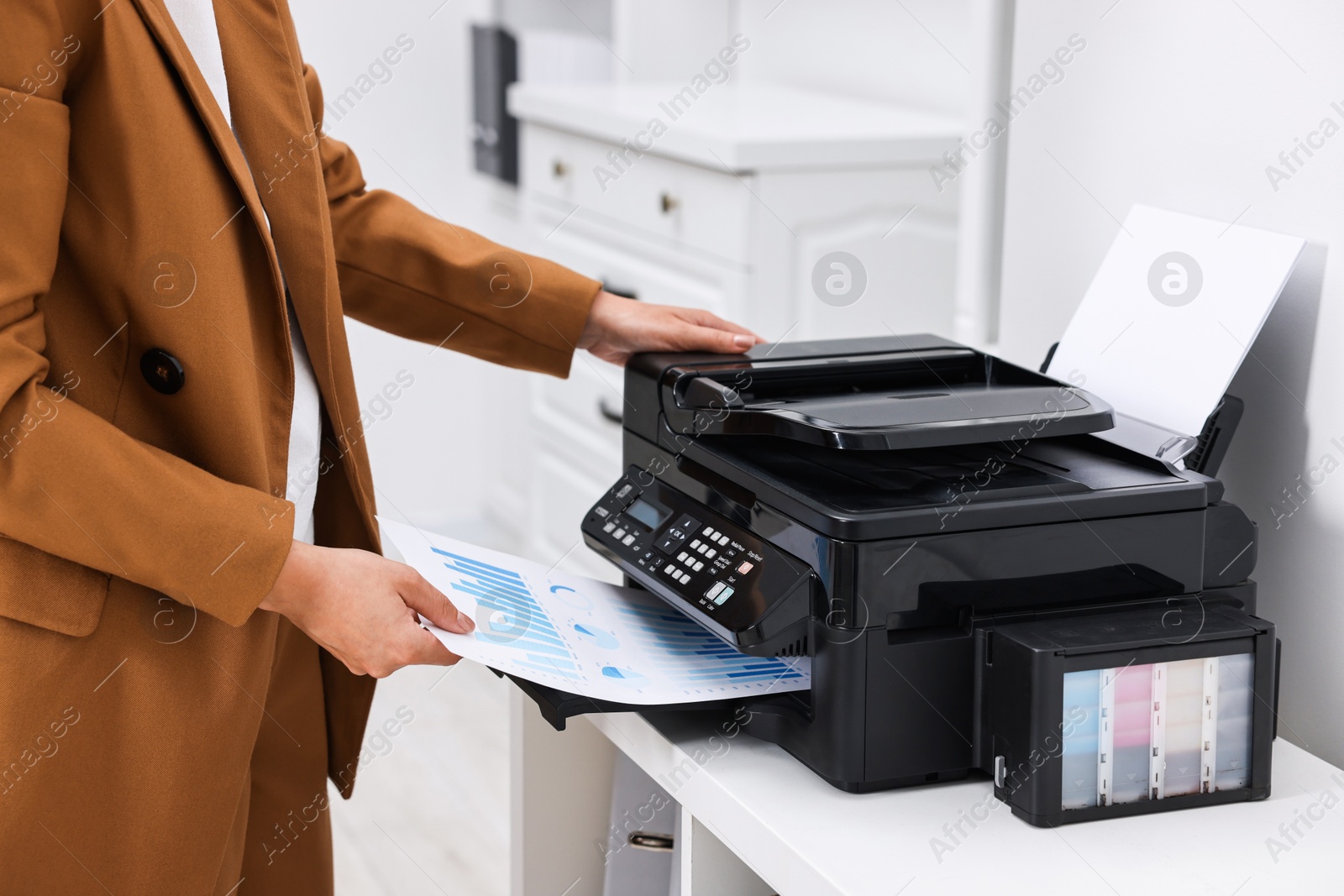 Photo of Woman using modern printer at workplace indoors, closeup