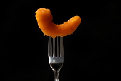 Fork with tasty fried shrimp on black background, closeup