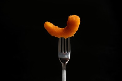 Fork with tasty fried shrimp on black background, closeup