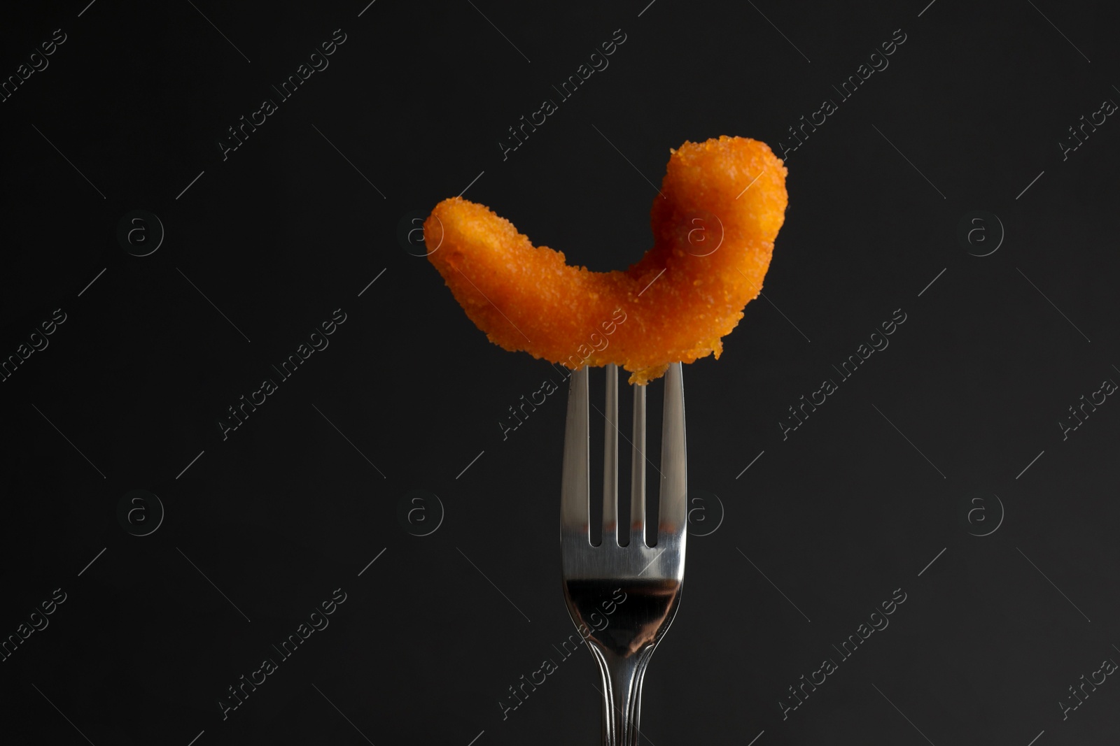 Photo of Fork with tasty fried shrimp on black background, closeup