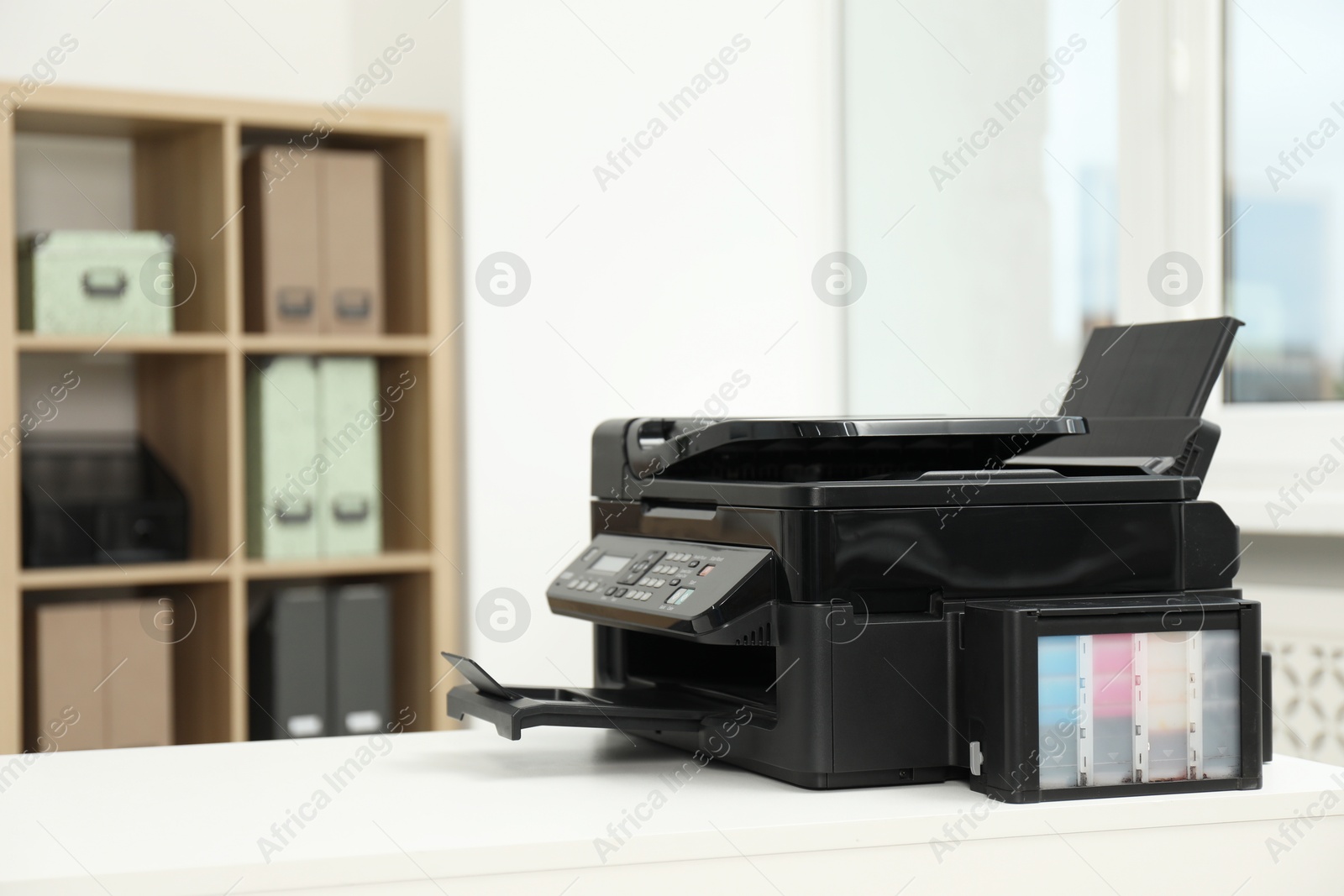 Photo of Modern printer on white table in office