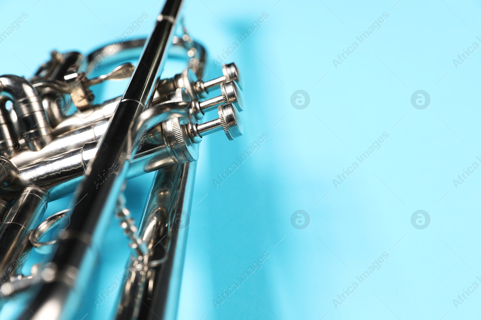 Photo of One trumpet on light blue background, closeup. Space for text