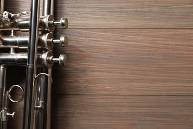 Photo of One trumpet on wooden table, top view. Space for text