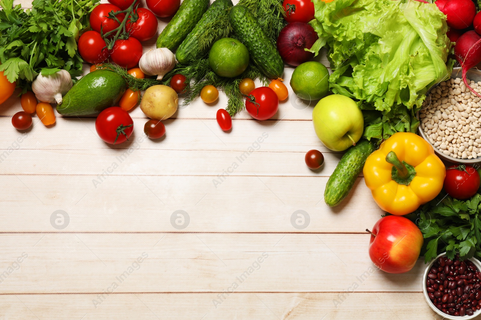 Photo of Different vegetarian products on light wooden table, top view. Space for text