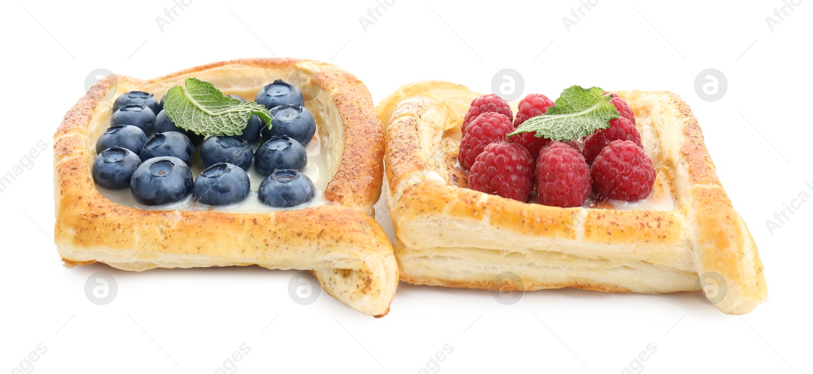 Photo of Tasty puff pastries with berries isolated on white