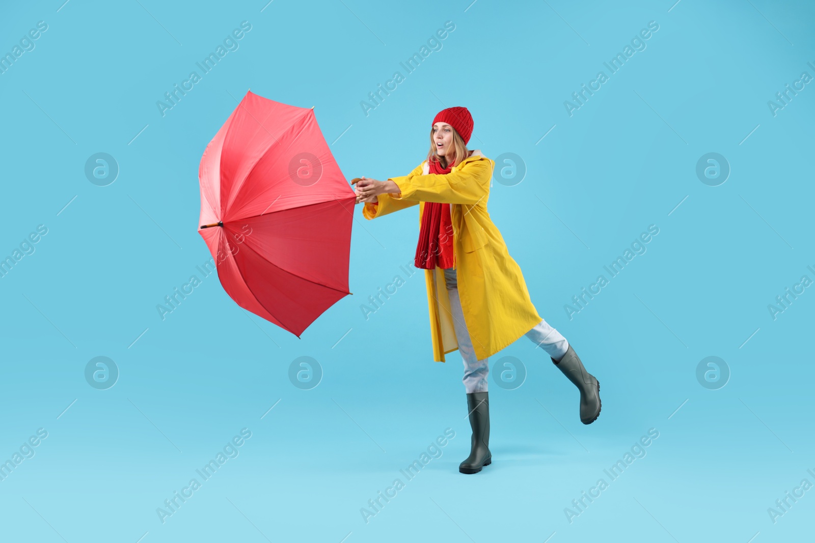 Photo of Woman with red umbrella on light blue background