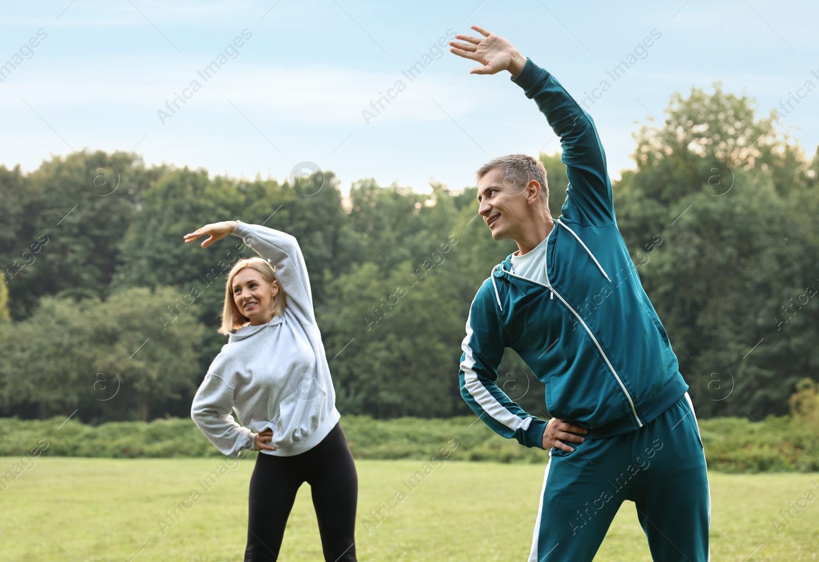 Photo of Happy couple doing exercises in park. Healthy lifestyle