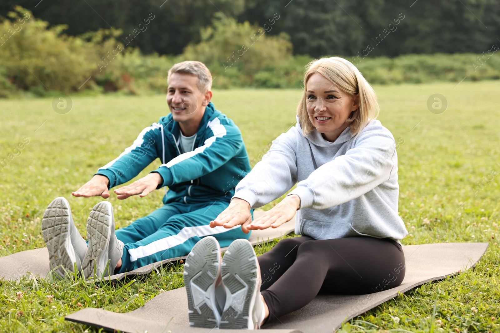 Photo of Happy couple doing exercises in park. Healthy lifestyle