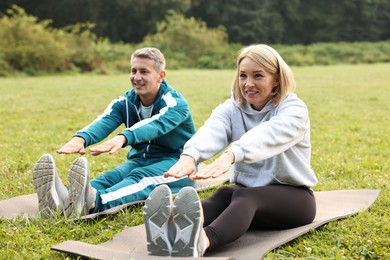 Happy couple doing exercises in park. Healthy lifestyle