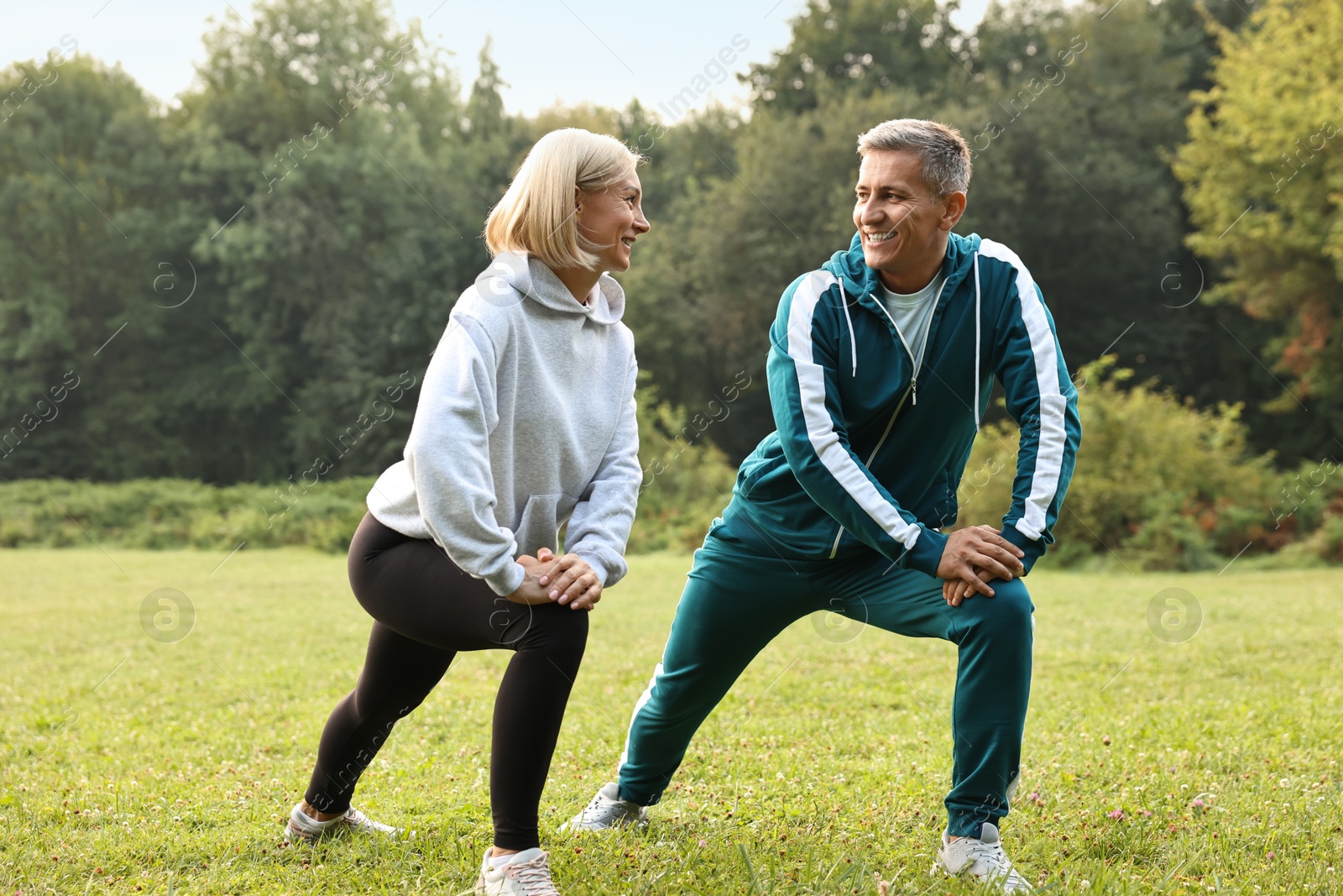 Photo of Happy couple doing exercises in park. Healthy lifestyle