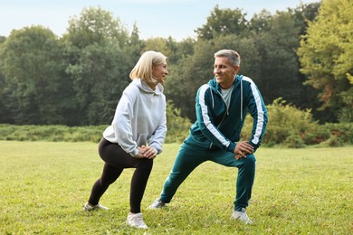 Photo of Happy couple doing exercises in park. Healthy lifestyle