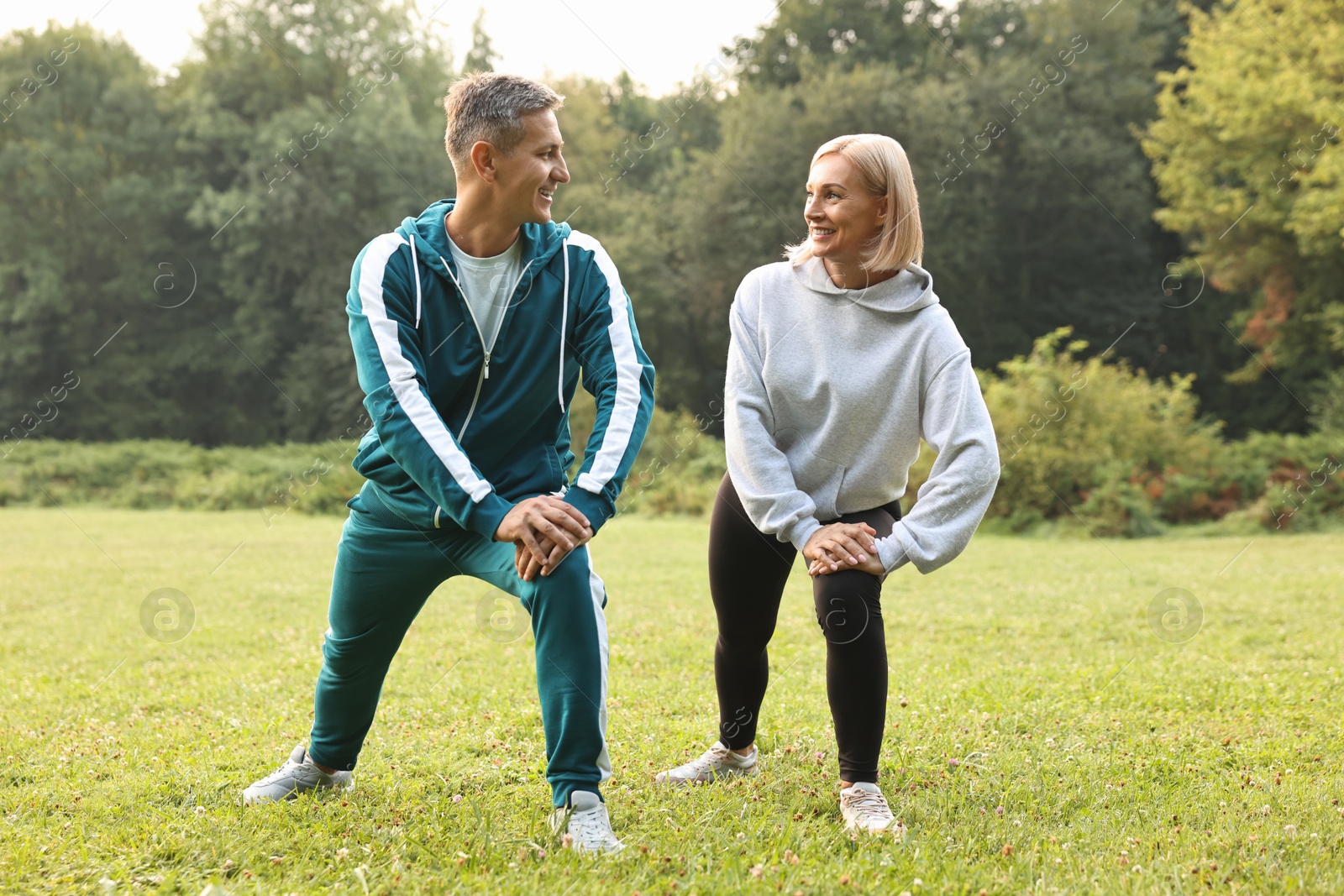 Photo of Happy couple doing exercises in park. Healthy lifestyle