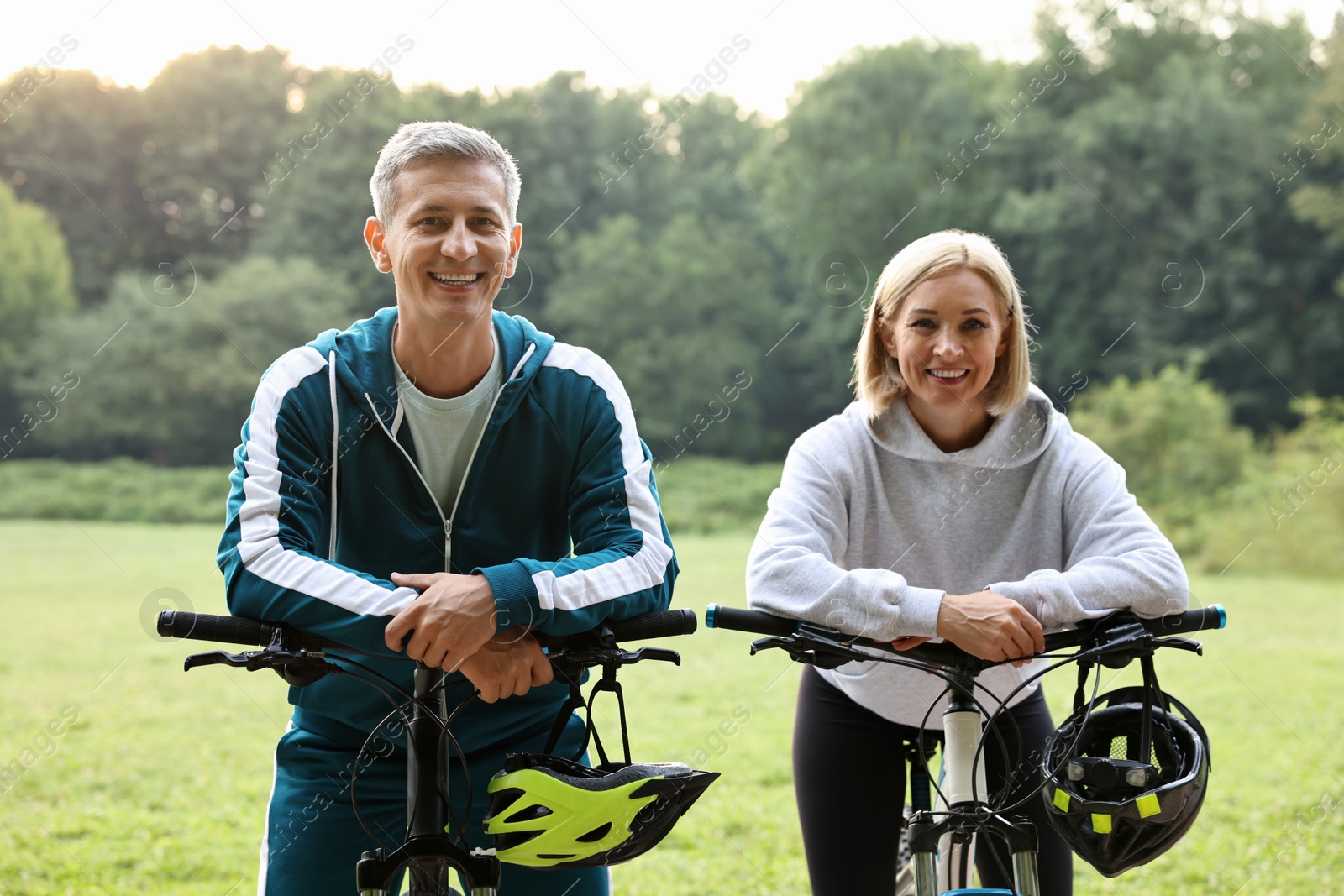 Photo of Happy couple with bicycles in park. Healthy lifestyle