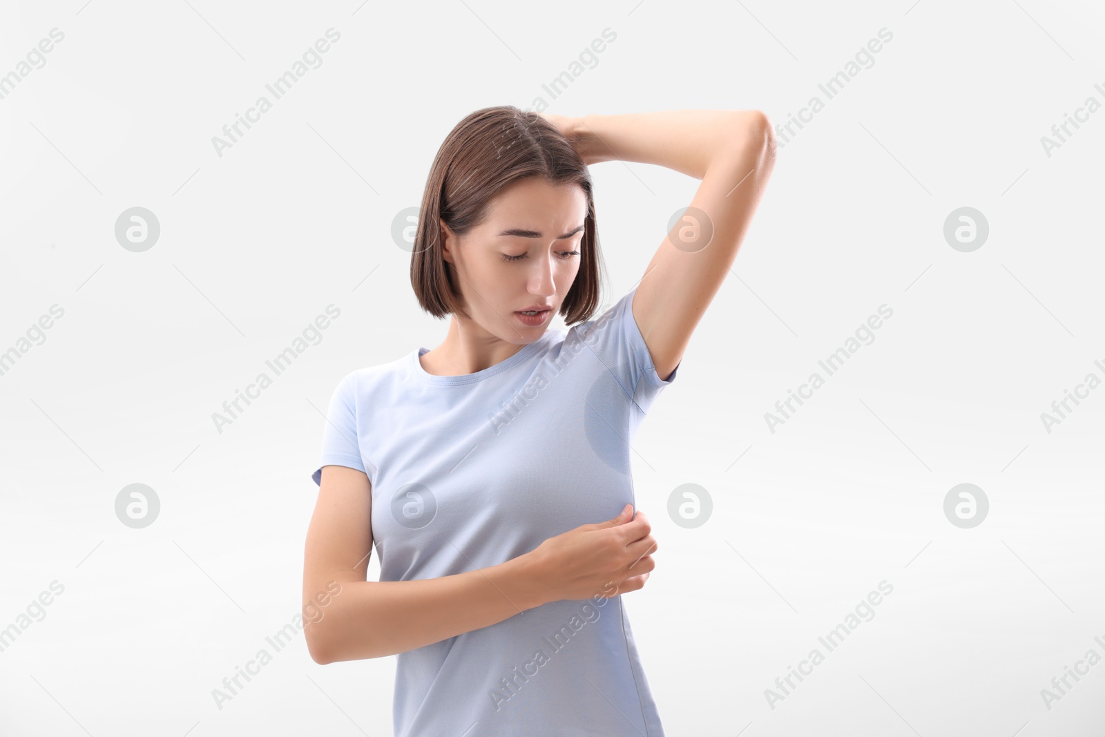 Photo of Emotional woman in t-shirt before using deodorant on white background