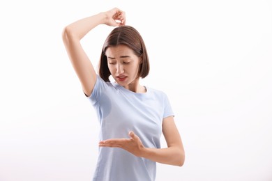 Photo of Emotional woman in t-shirt before using deodorant on white background