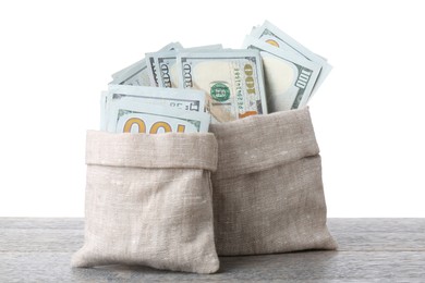 Photo of Dollar banknotes in bags on wooden table against white background