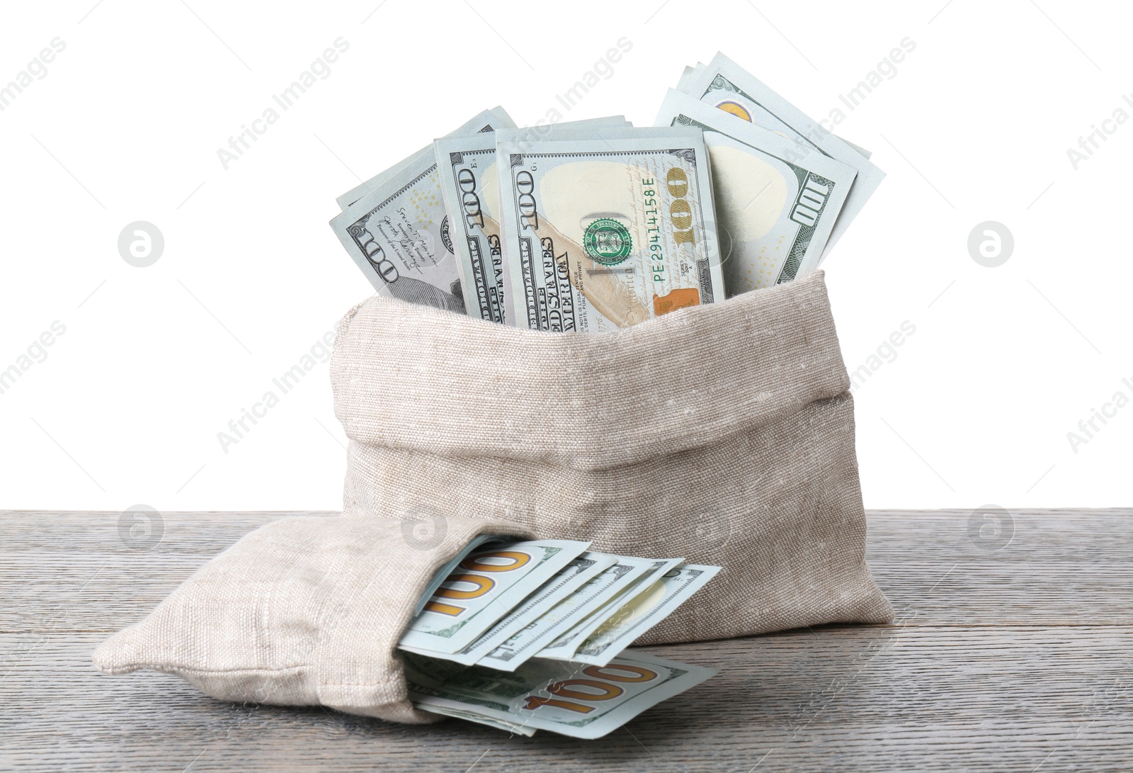 Photo of Dollar banknotes in bags on wooden table against white background