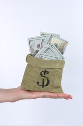 Photo of Woman with bag of dollar banknotes against light background, closeup