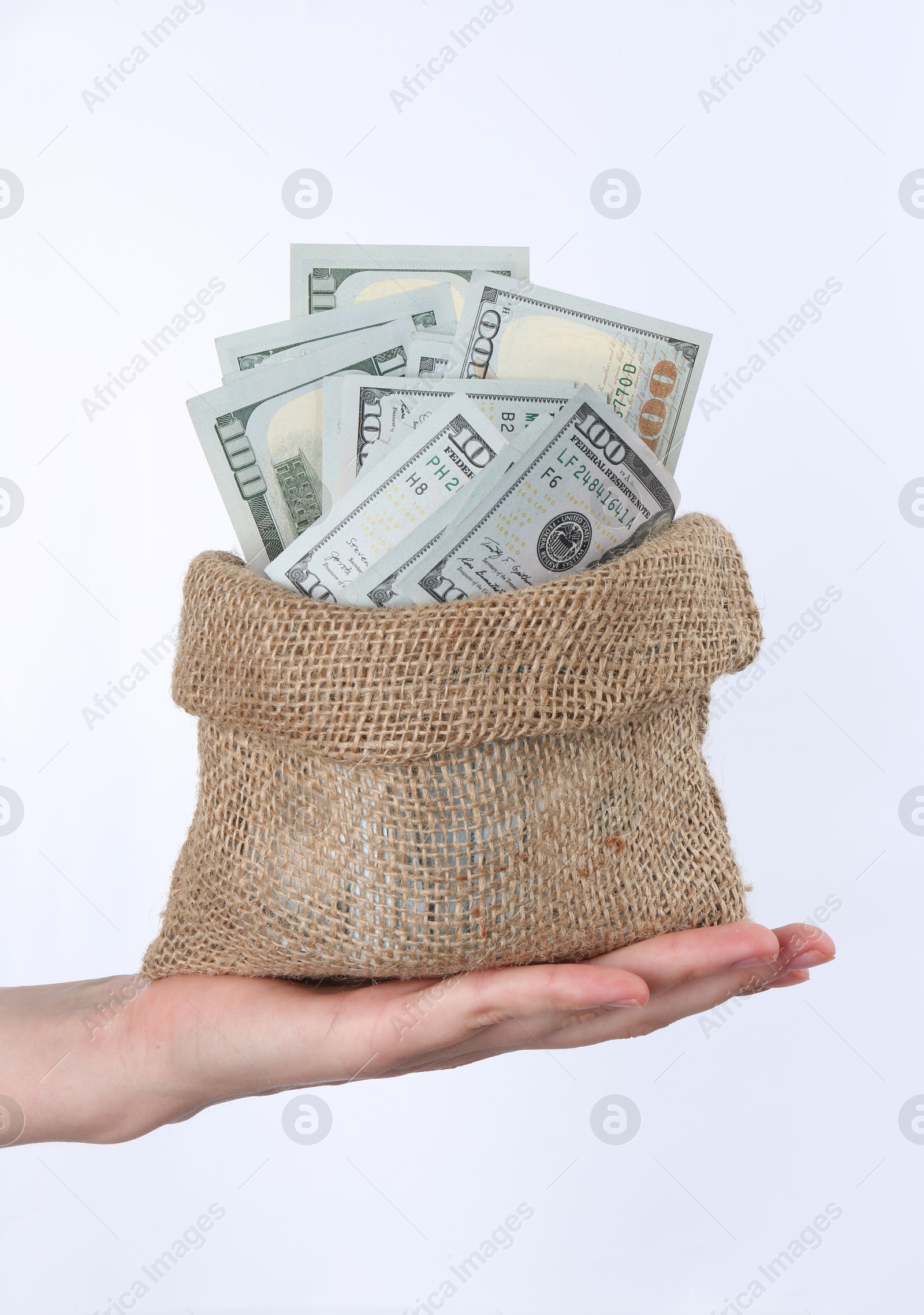 Photo of Woman with bag of dollar banknotes against light background, closeup