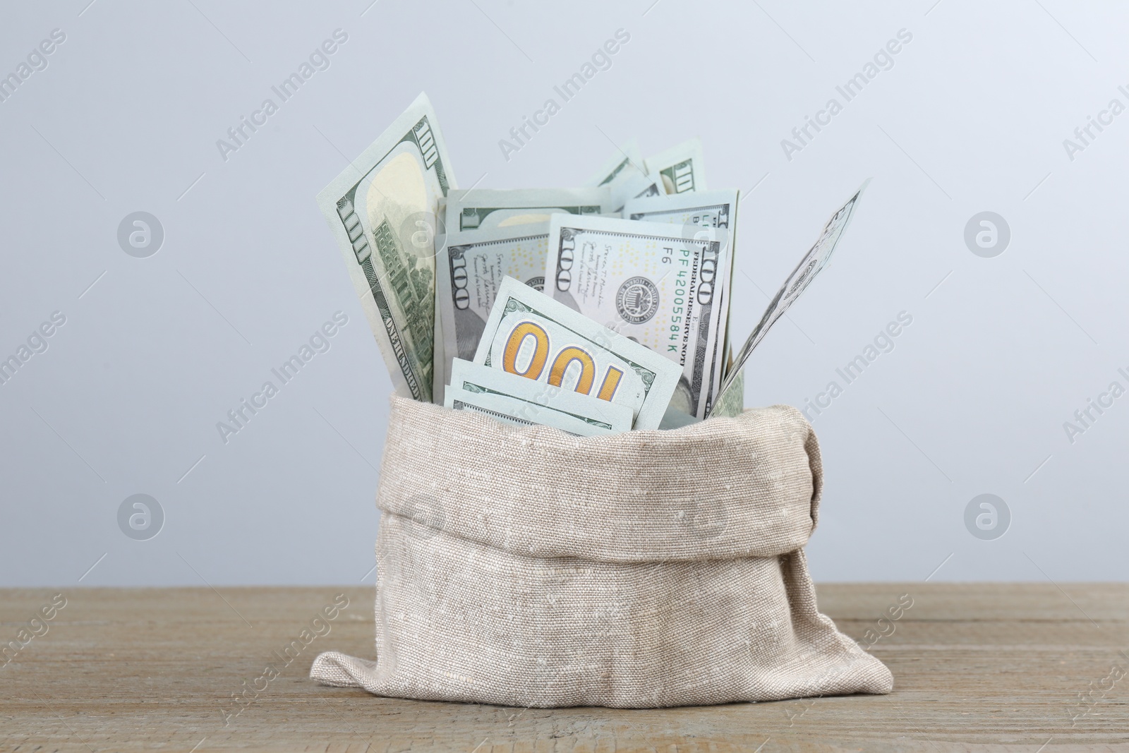 Photo of Dollar banknotes in bag on wooden table