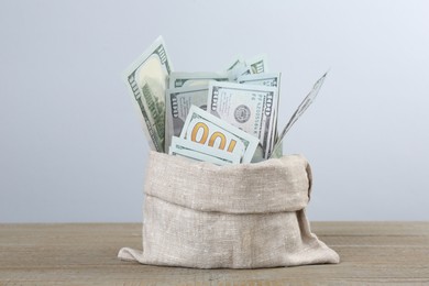 Photo of Dollar banknotes in bag on wooden table