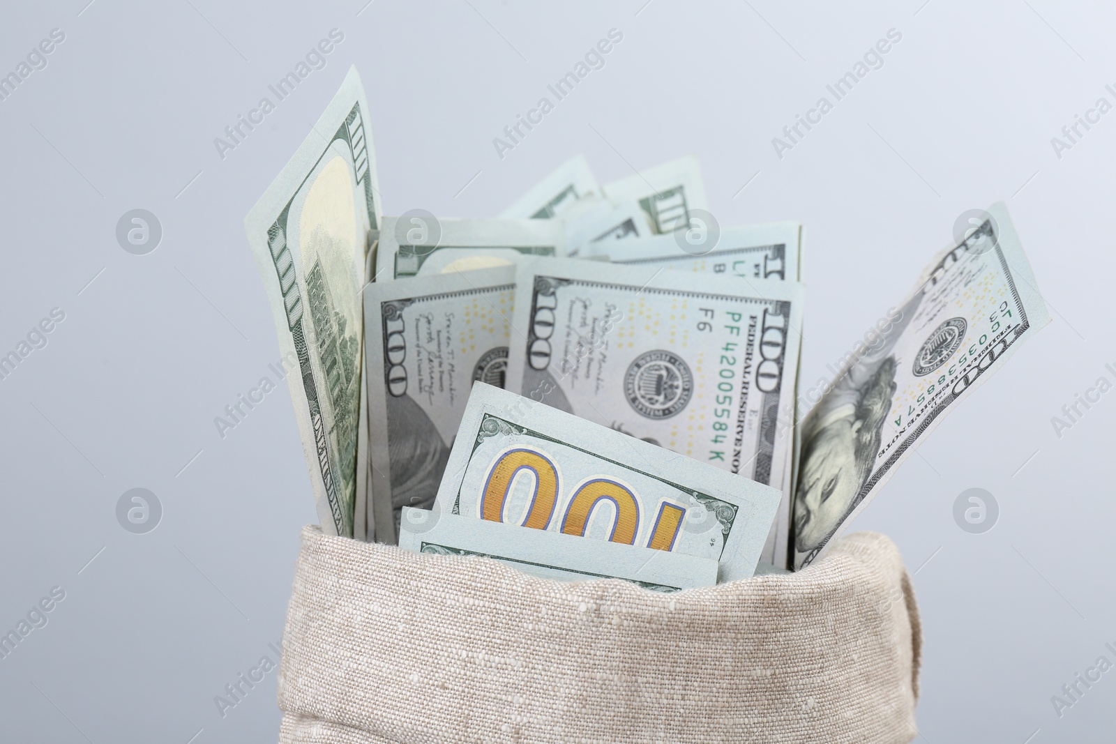 Photo of Dollar banknotes in bag against grey background, closeup