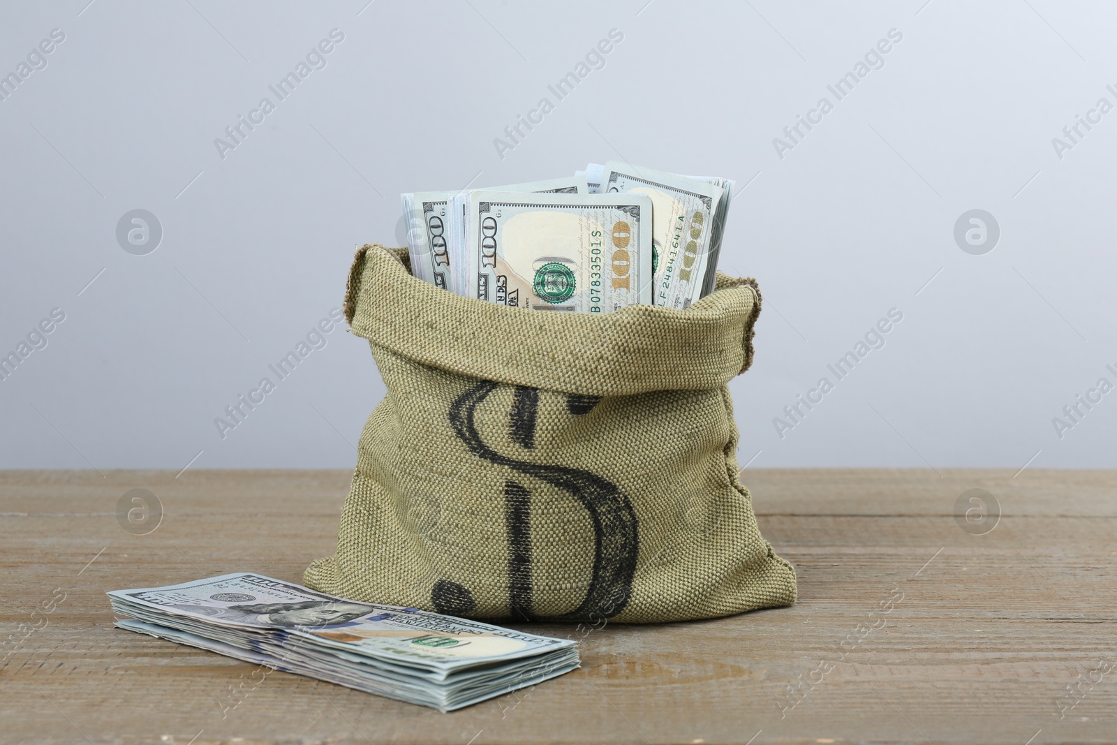 Photo of Dollar banknotes in bag on wooden table