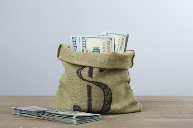 Photo of Dollar banknotes in bag on wooden table