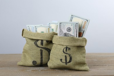 Photo of Dollar banknotes in bags on wooden table