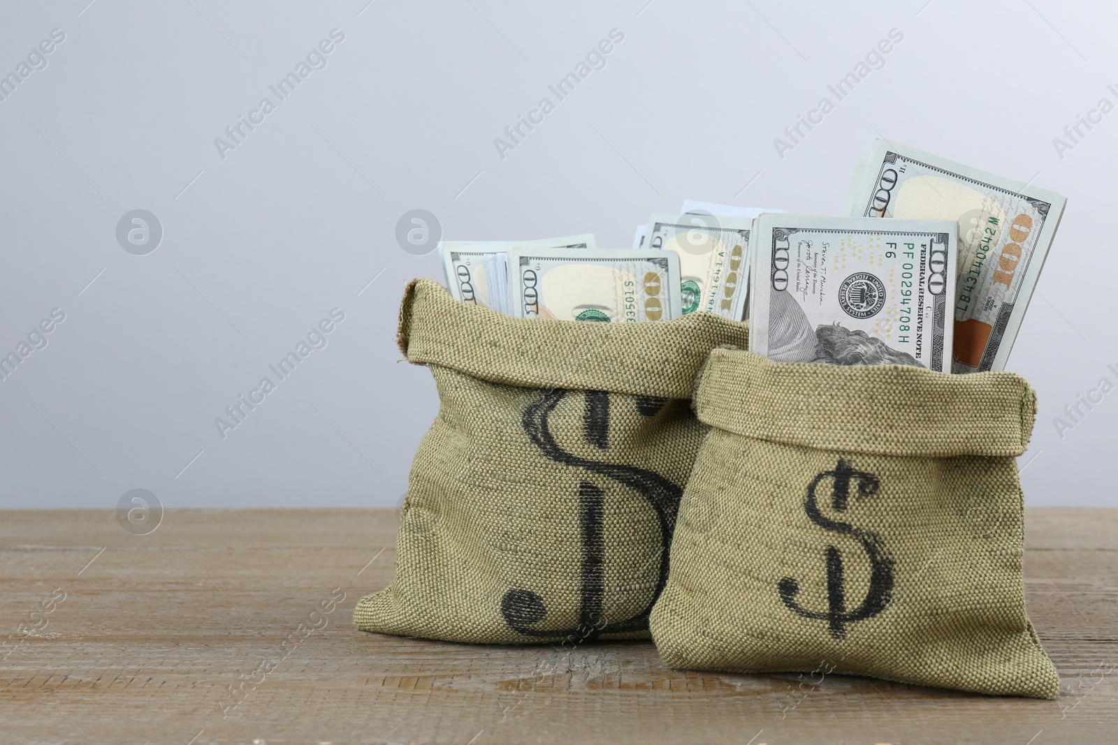 Photo of Dollar banknotes in bags on wooden table