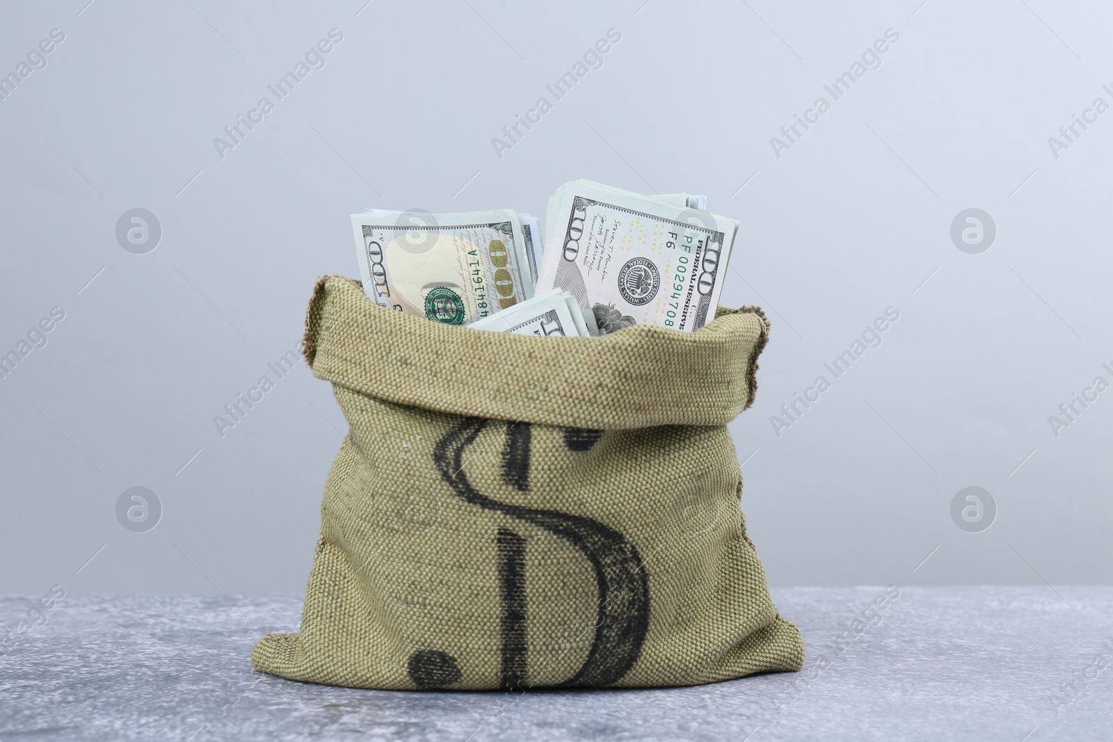 Photo of Dollar banknotes in bag on grey textured table