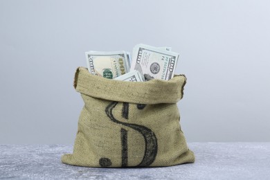 Photo of Dollar banknotes in bag on grey textured table