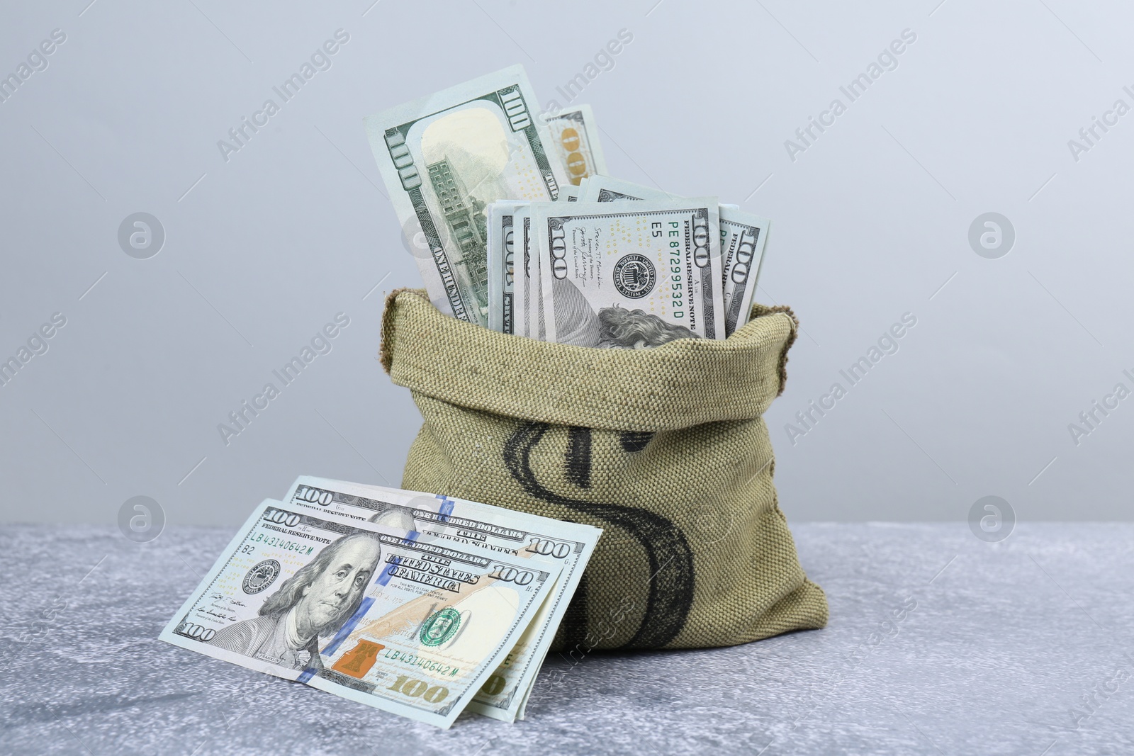 Photo of Dollar banknotes in bag on grey textured table