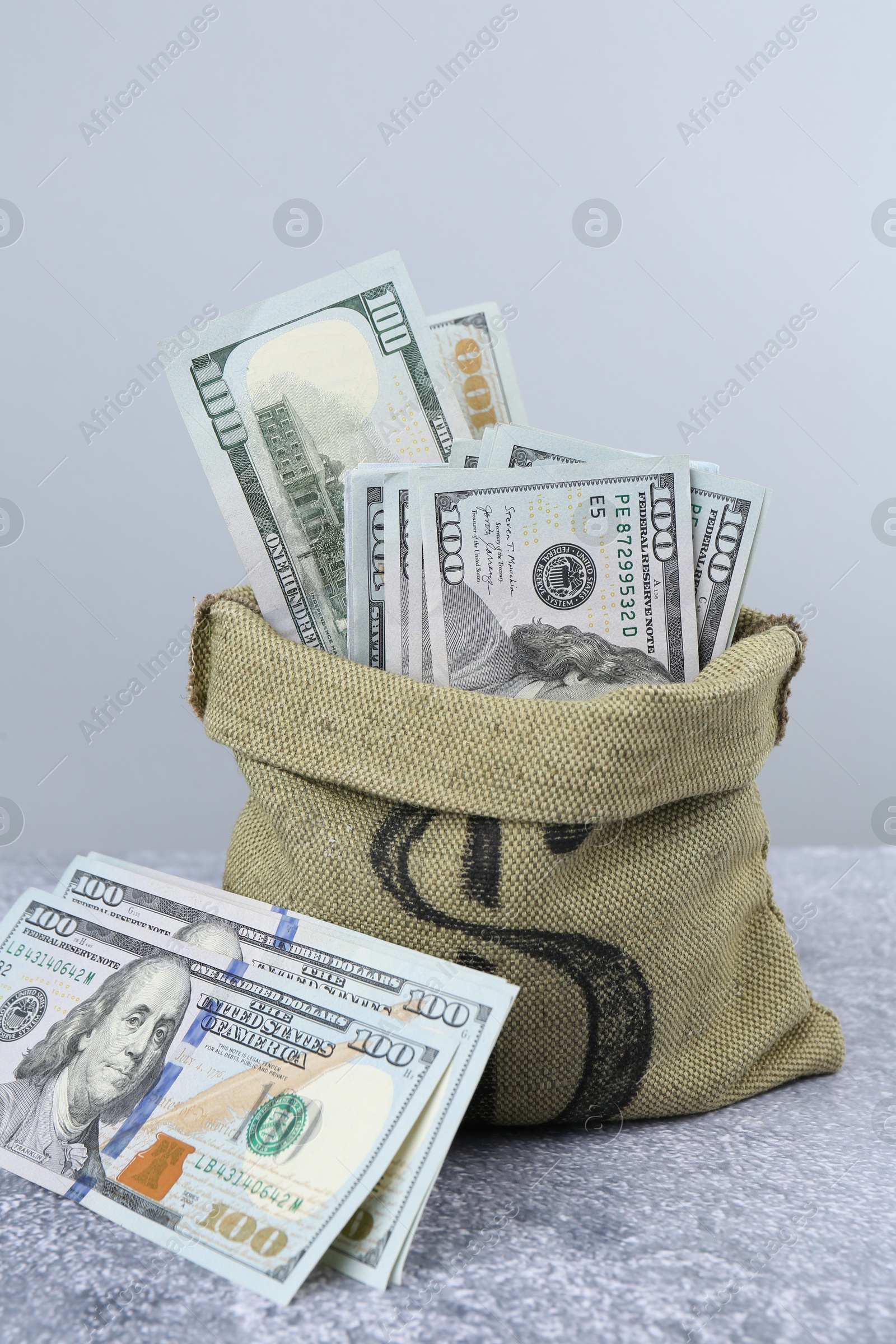 Photo of Dollar banknotes in bag on grey textured table