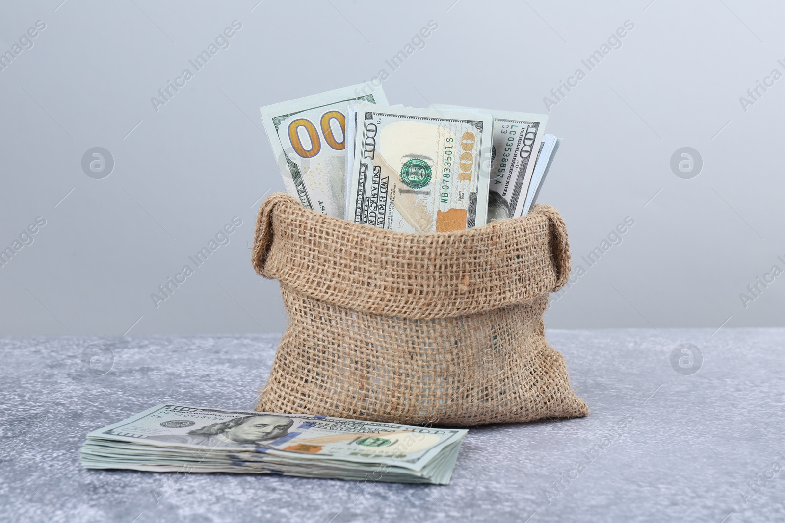 Photo of Dollar banknotes in bag on grey textured table