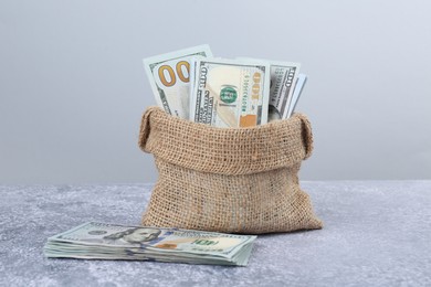 Photo of Dollar banknotes in bag on grey textured table