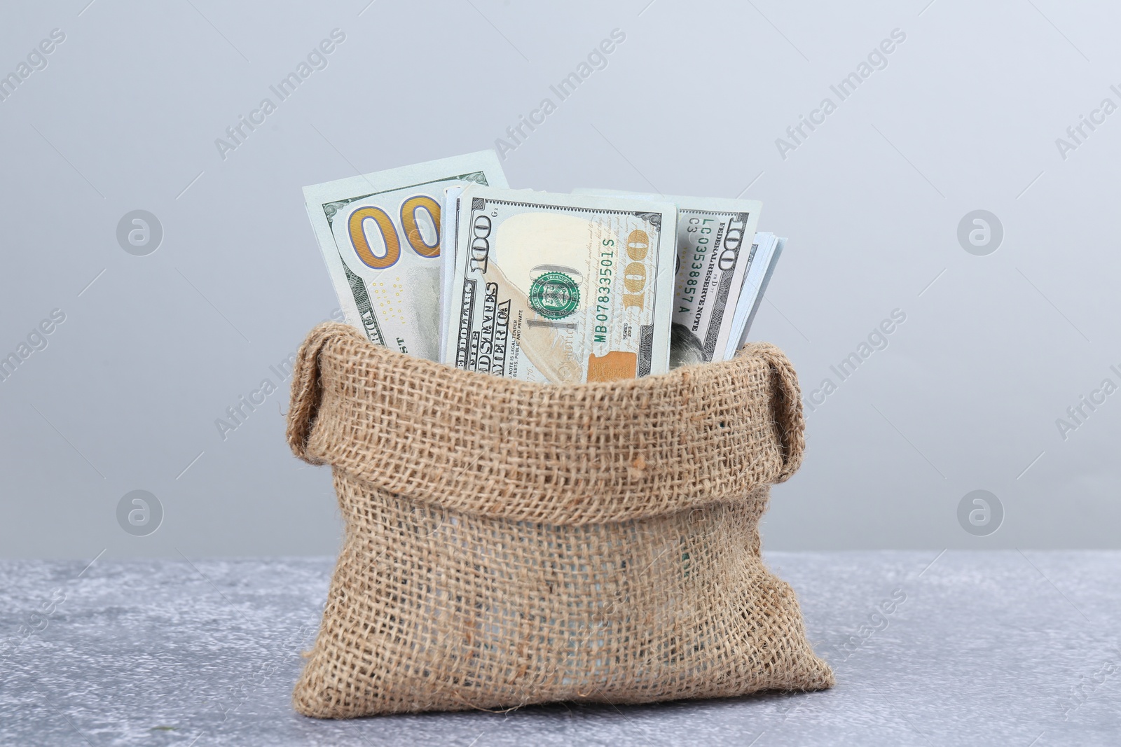 Photo of Dollar banknotes in bag on grey textured table