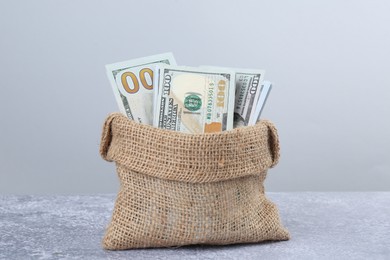 Photo of Dollar banknotes in bag on grey textured table